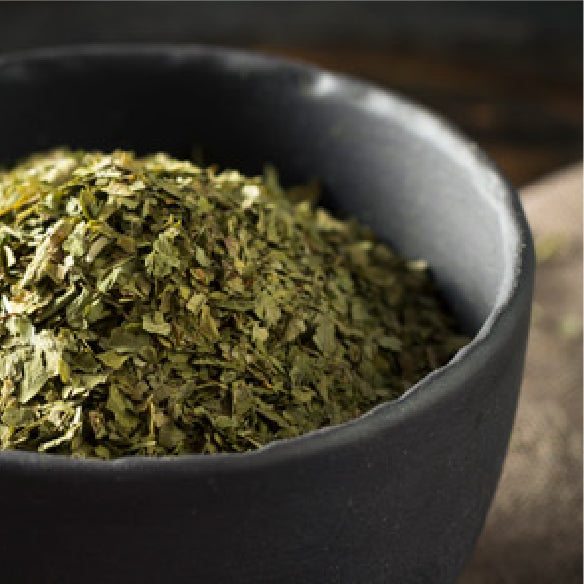 Chopped dried cilantro in a dark bowl