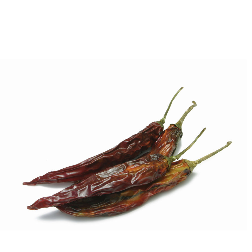 Three dried red chili peppers on a white background