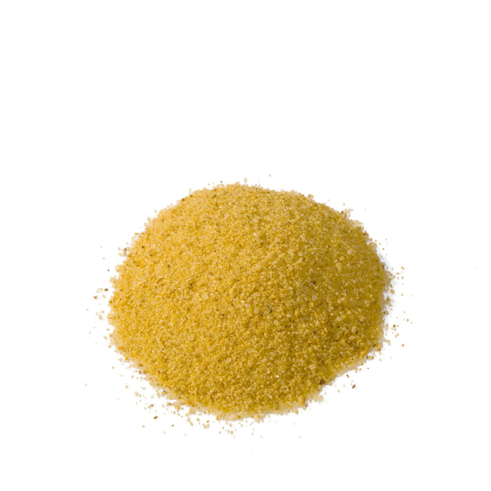 Pile of golden yellow seasoning salt on a white background.