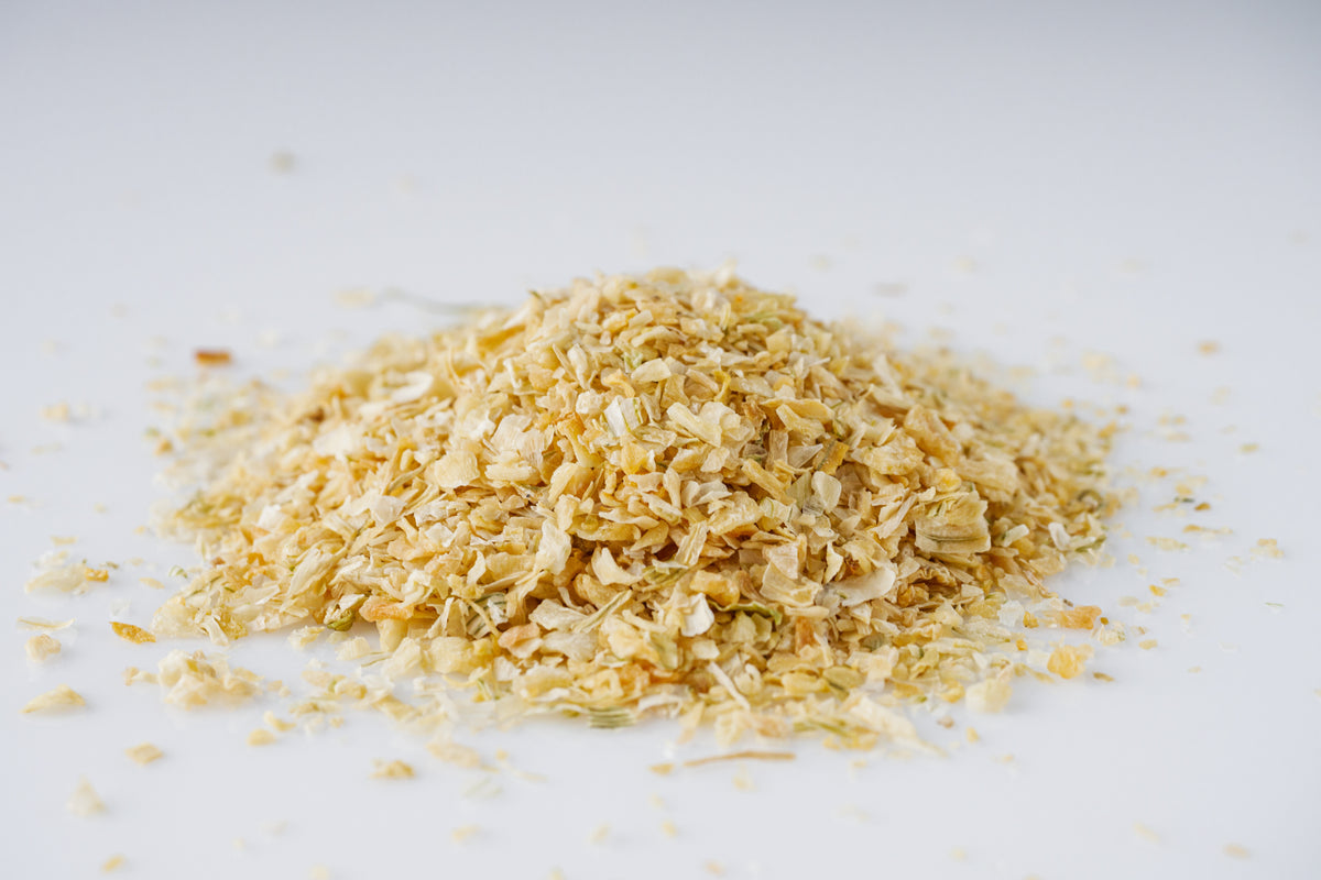 Pile of chopped onions scattered on a white surface