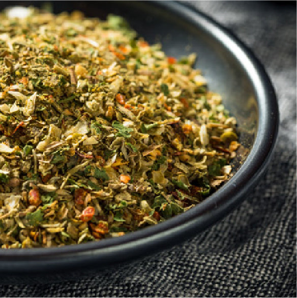 Pizza seasoning blend with herbs and spices on a dark plate
