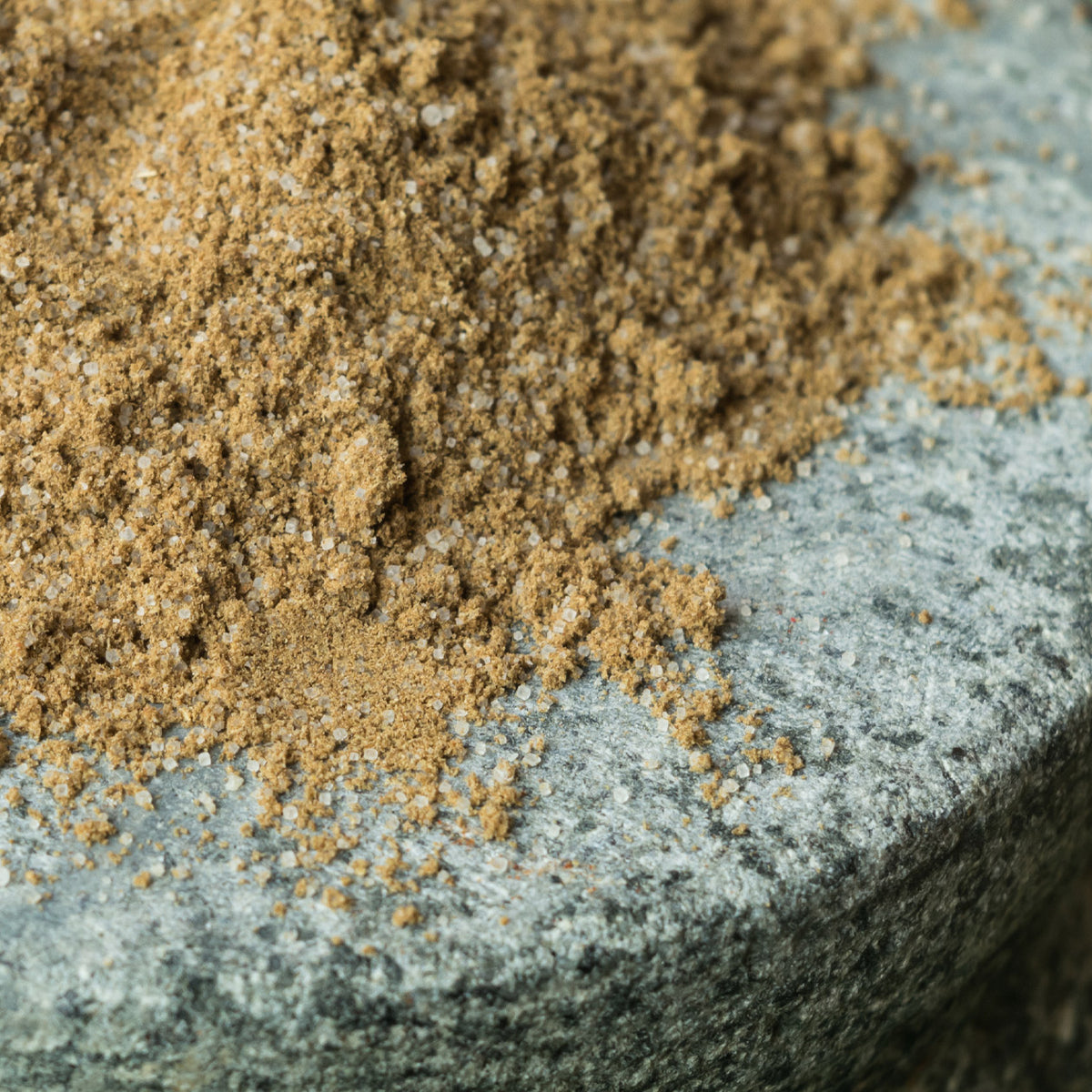 Close up of celery salt granules on a textured stone surface