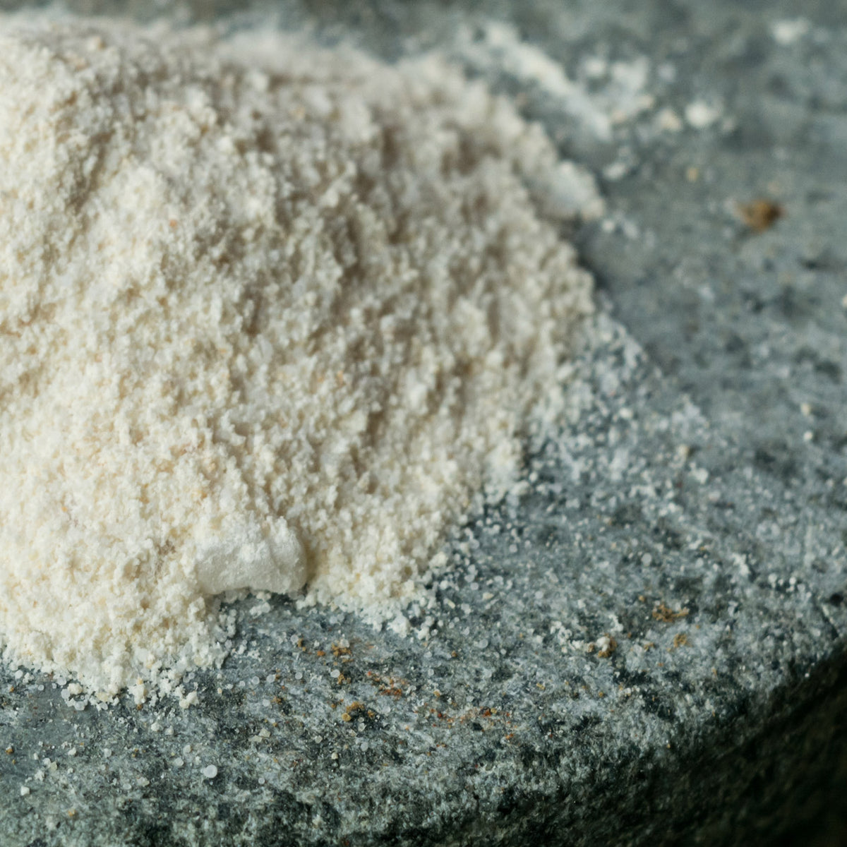 Pile of garlic salt seasoning on a dark stone surface