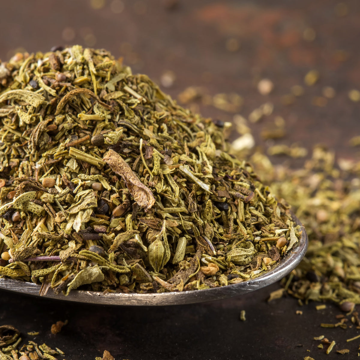 Pile of dried thyme on a metal spoon with a dark background