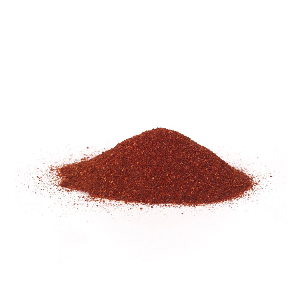 Red paprika powder piled into a small mound on a white background